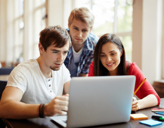 Three students in front of laptop